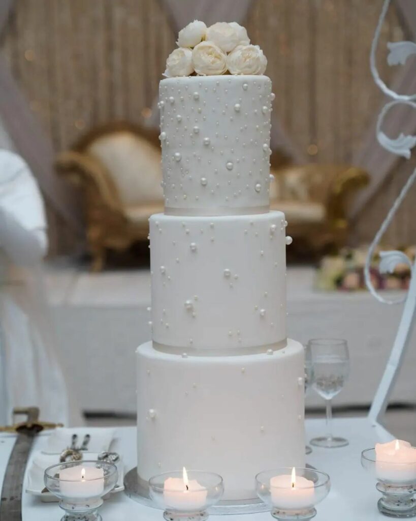 simple three tier pearl wedding cake with flowers