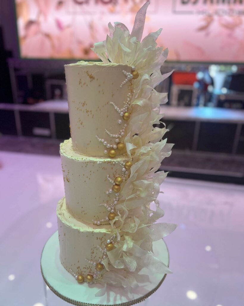 three tier white and gold pearl beaded wedding cake
