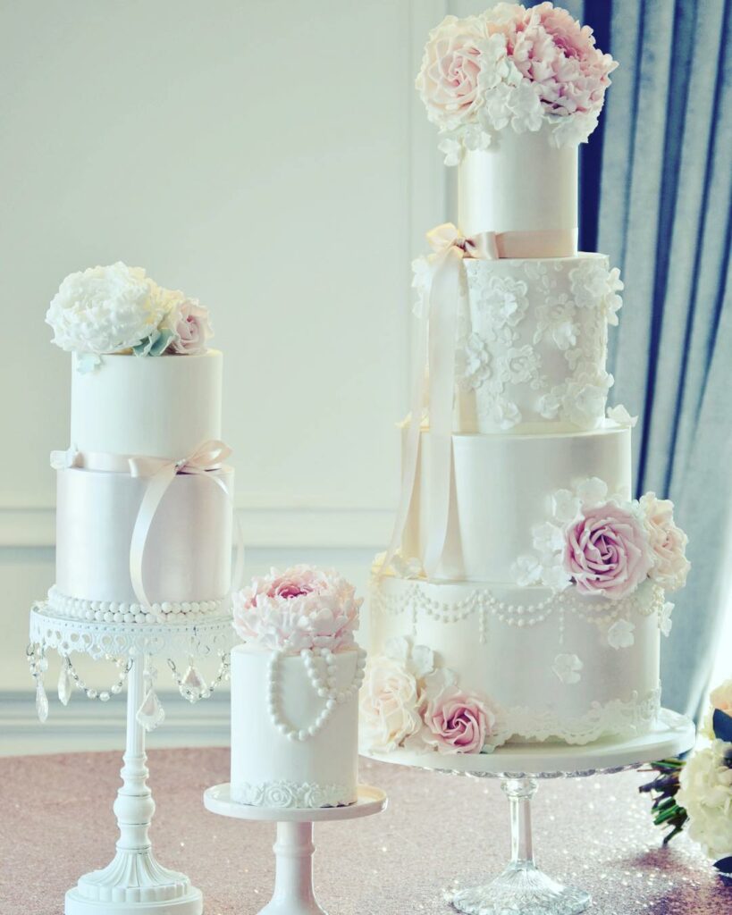 trio pearl adorned blush and white lace wedding cake