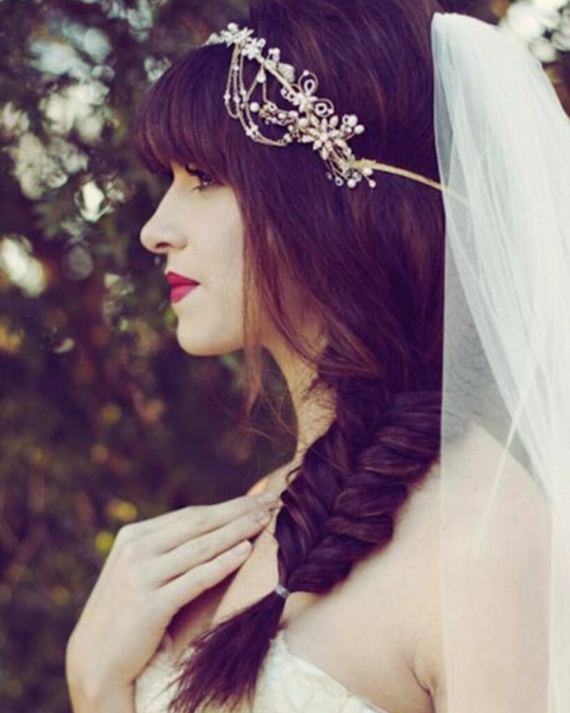 A classic braid with a modern twist adorned with an intricate headpiece and a traditional veil