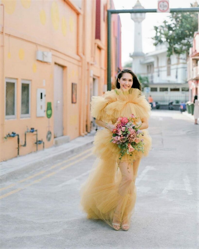A sunlit stroll in a dreamy tulle yellow wedding gown painting the town in shades of wedding bliss