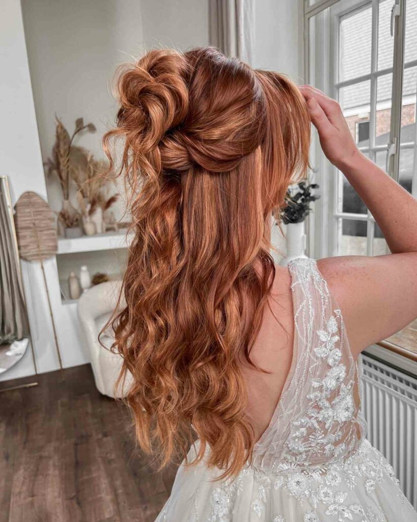 Elegant red hair styled in a romantic twisted half updo adorned with a delicate hairpiece