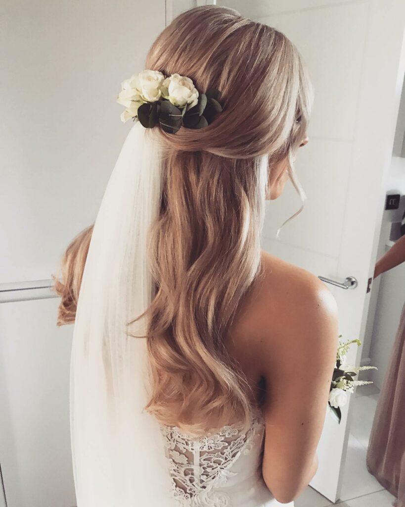 Soft and gentle waves loose pulled back pretty half up half down hairstyle with veil
