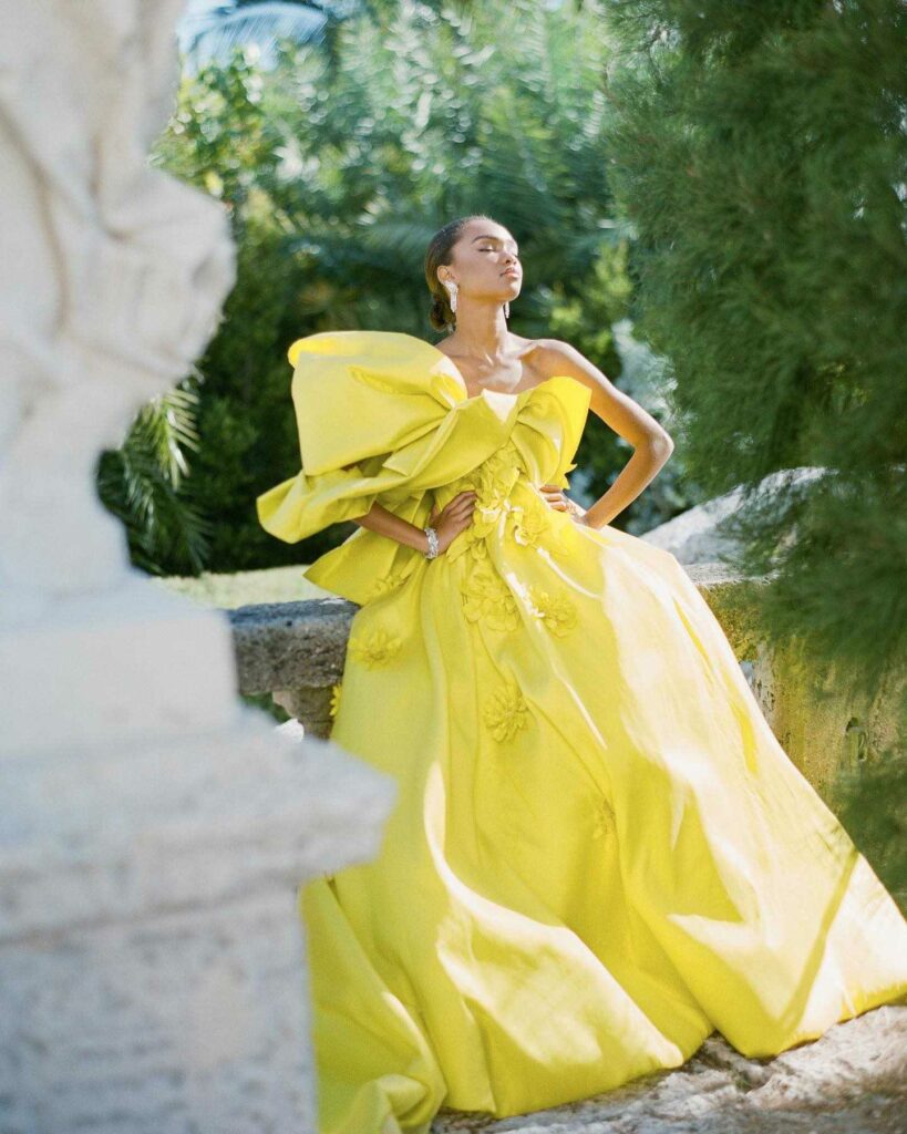 The garden is embraced by a vision in a yellow bridal dress bathed in the brightness of nature