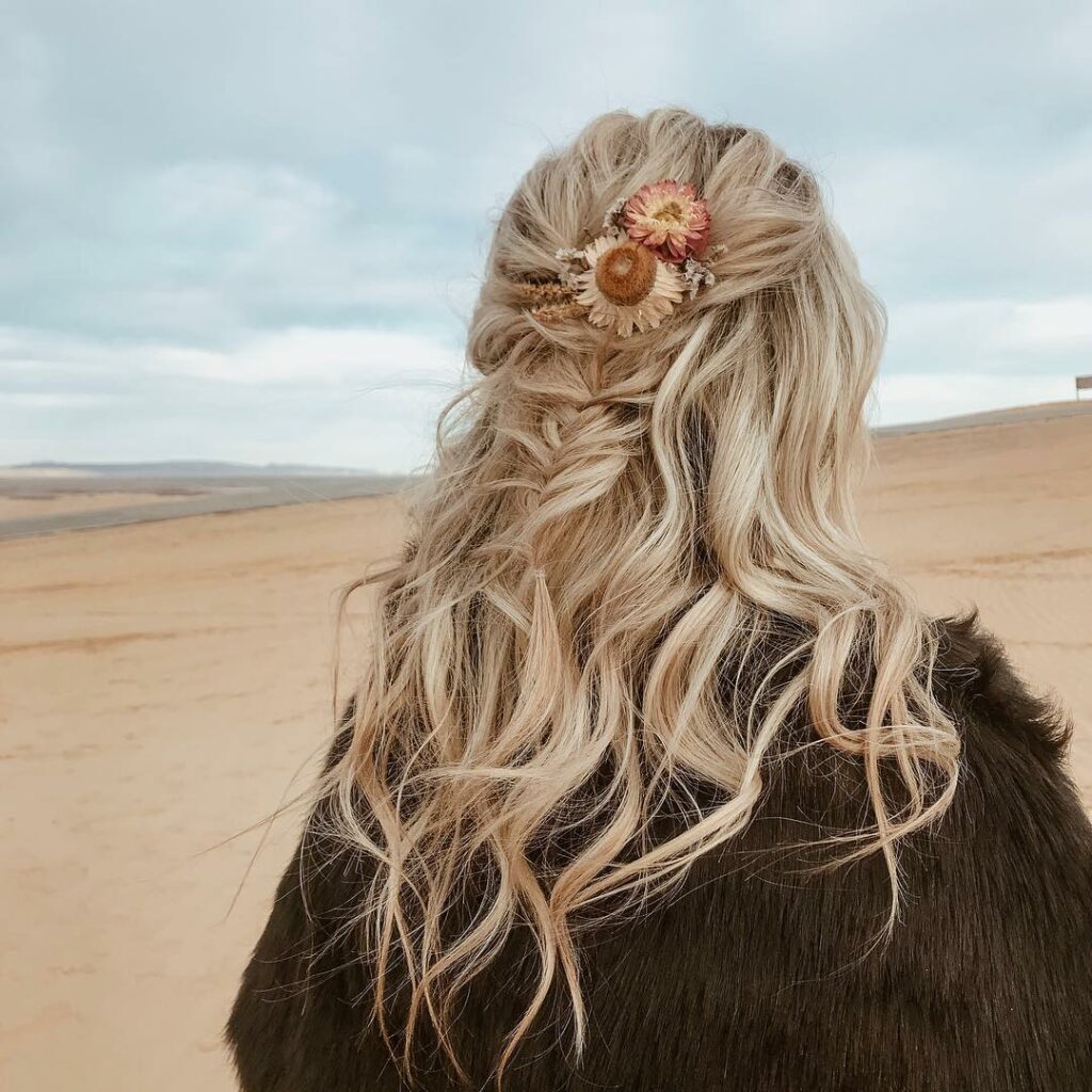 bohemian inspired wavy blonde hairstyle accentuated with a rustic floral hair accessory