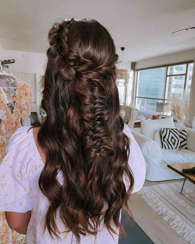 cascading braid with romantic waves half up half down elegant wedding hairstyle