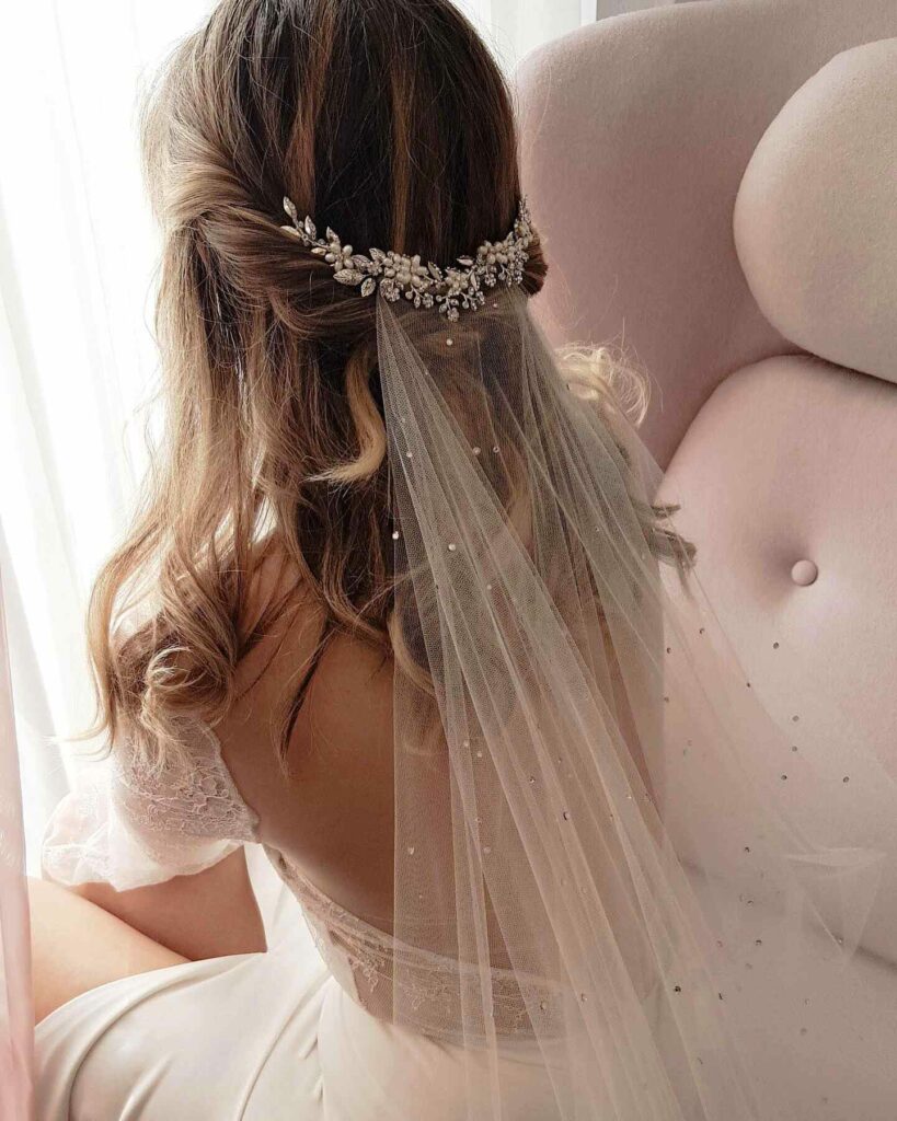 classic twisted half up wedding hairstyle with head piece and veil