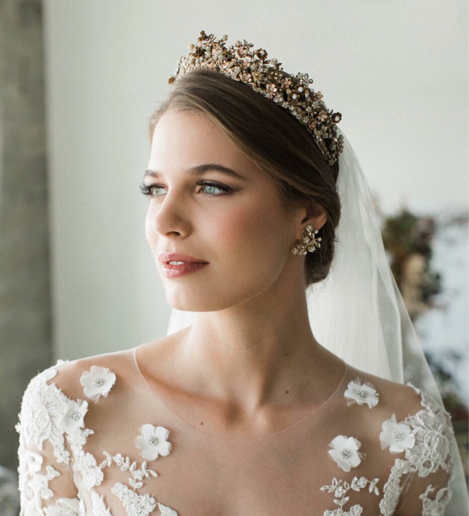 elegant low updo wedding hairstyle for royal bridal look with statement hair comb and veil