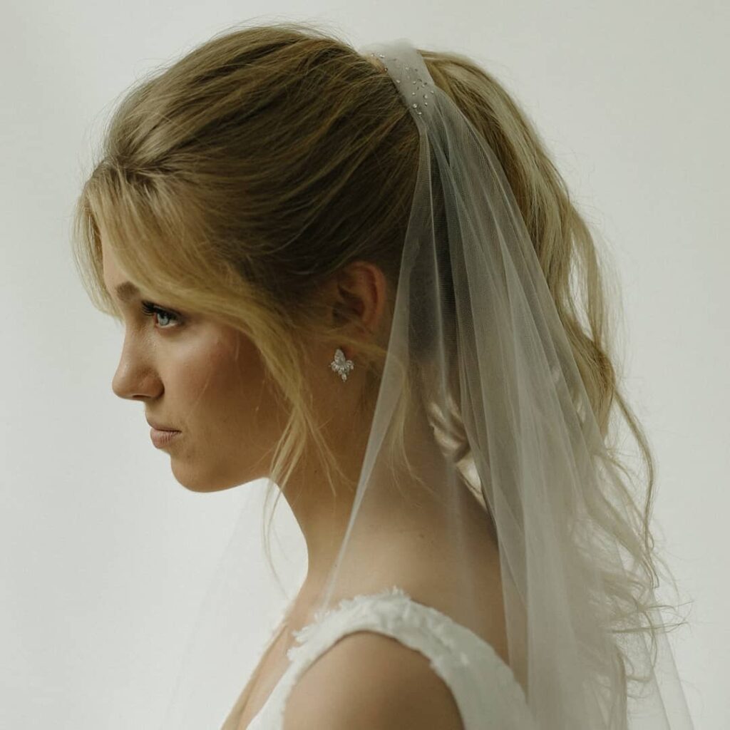 ponytail wedding hairstyle with traditional fingertip veil