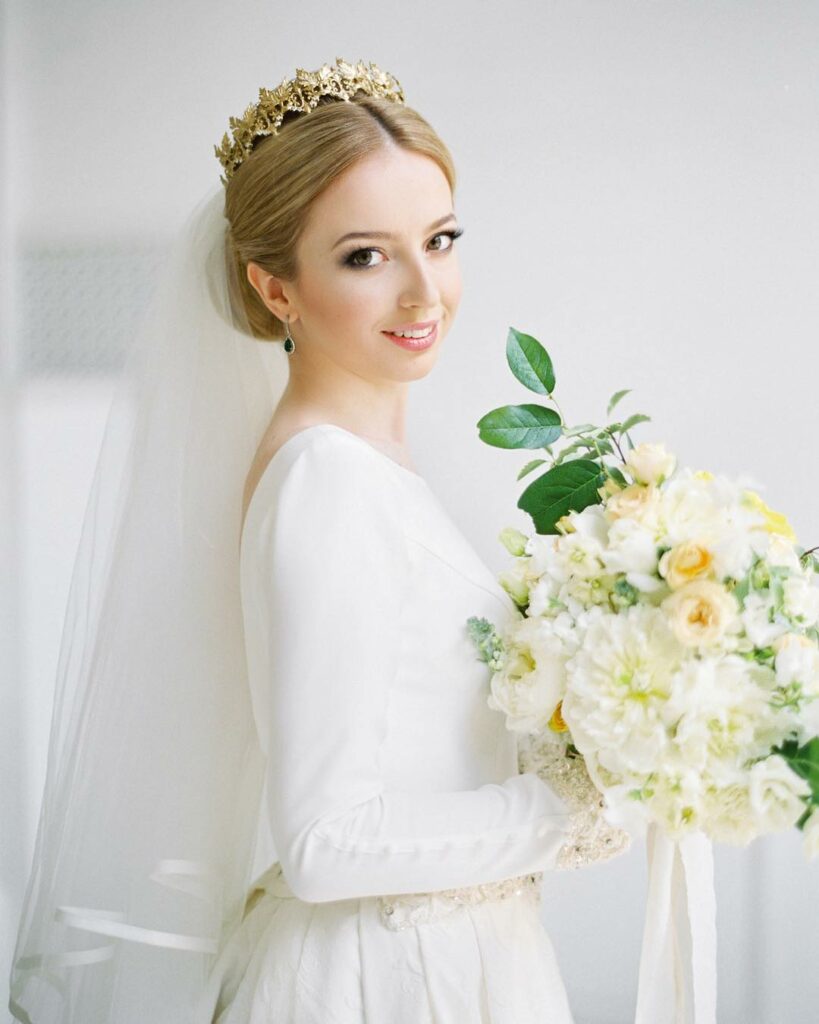 pretty bride in chignon wedding hairstyle with crown and veil