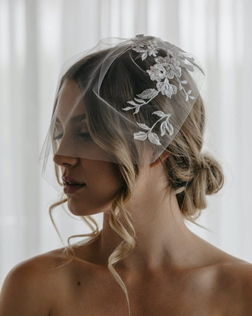 romantic loose curl updo with birdcage veil
