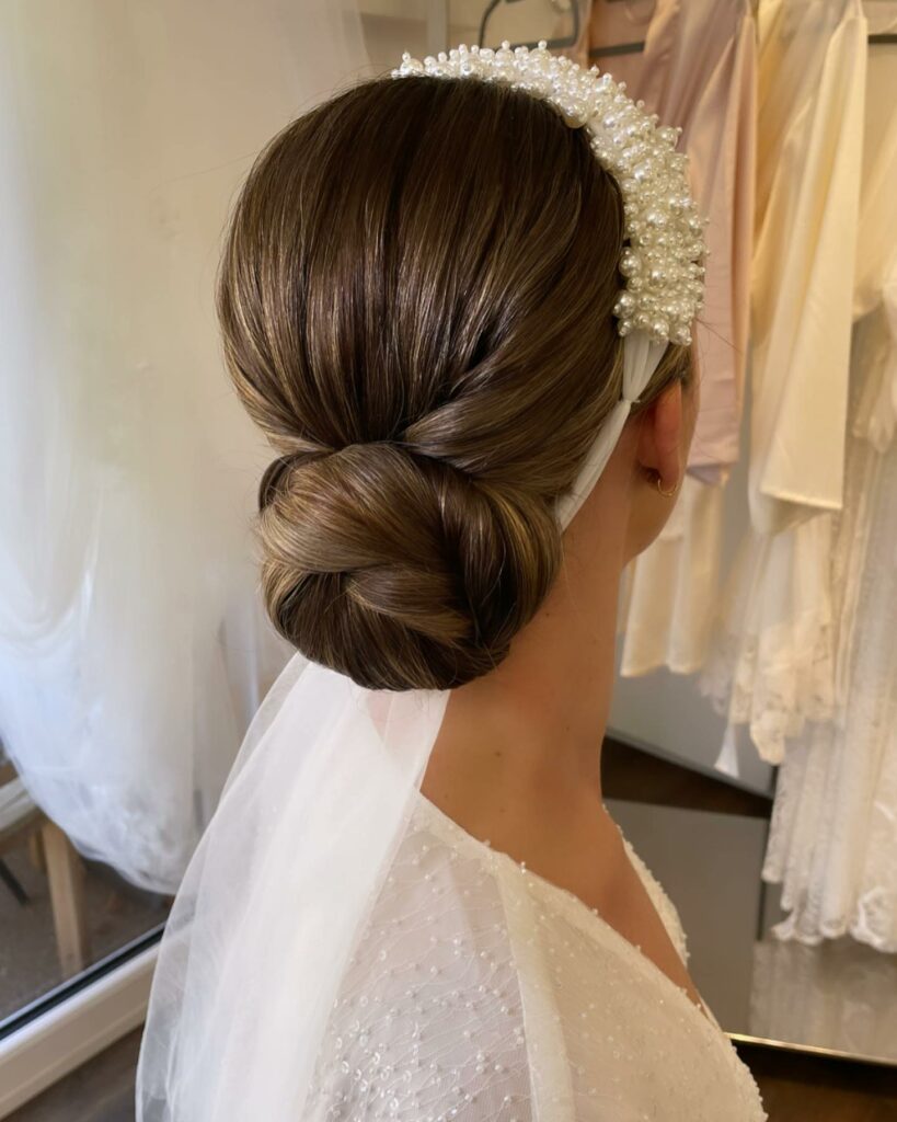 simple low bun wedding hairstyle to complement a statement head piece