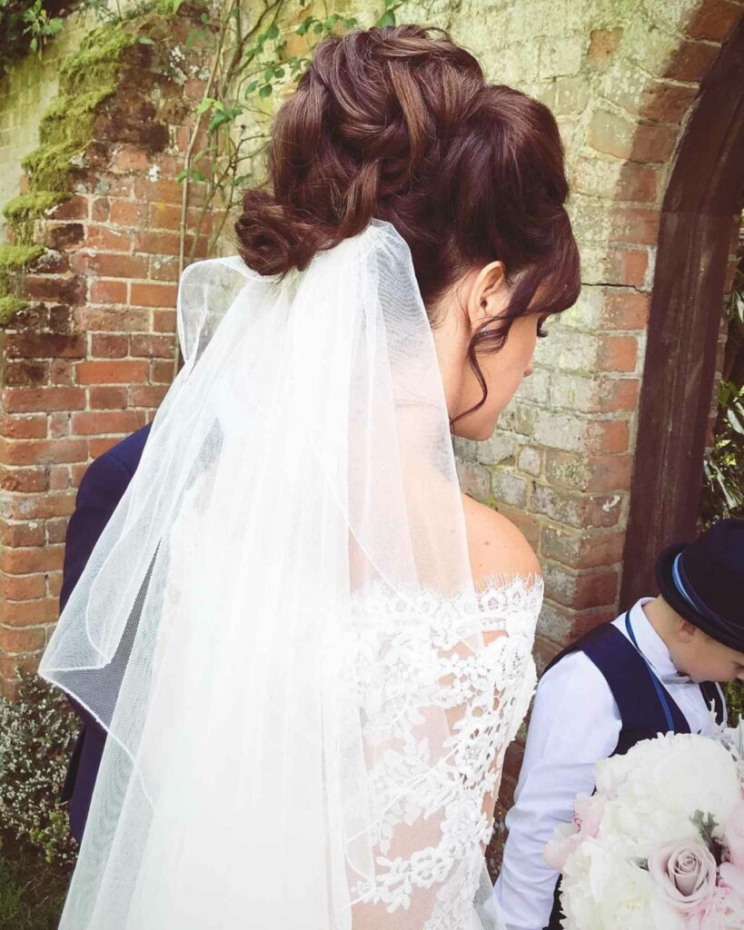 soft tussled updo with veil medium wedding hairstyle
