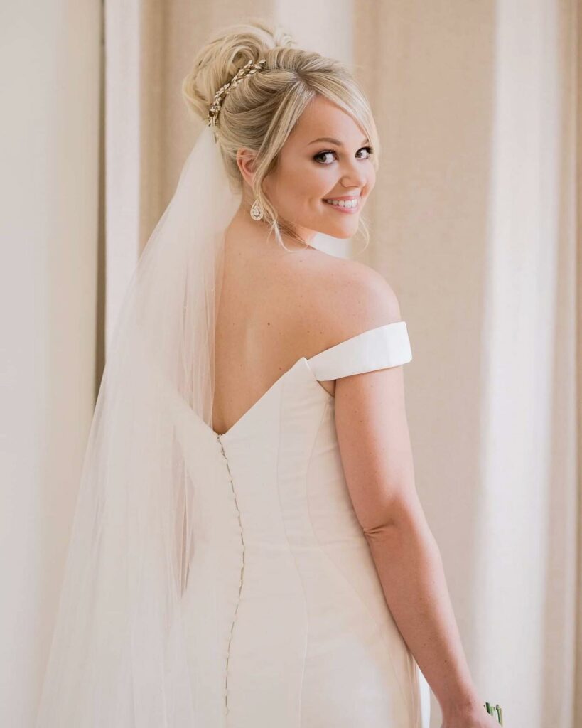 stunning swirling high bun wedding hairstyle finished with Charlotte com and veil
