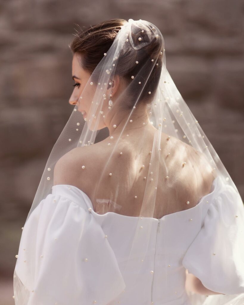 top knot wedding hairstyle with pearl veils