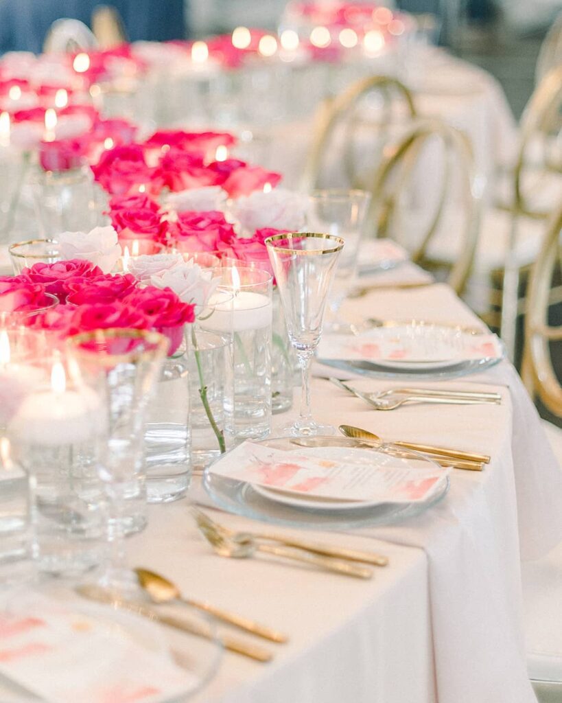 A centerpiece of floating candles illuminates a tablecloth of pink and white blossom
