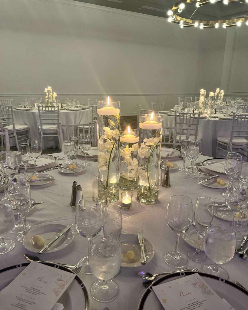cylinders with white orchid and floating candles on top wedding centerpiece