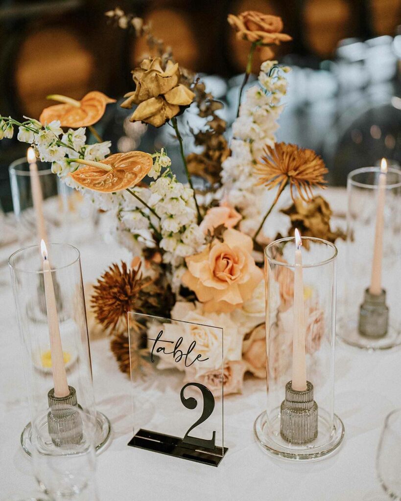 elegant wedding centerpiece with taper candles and table number