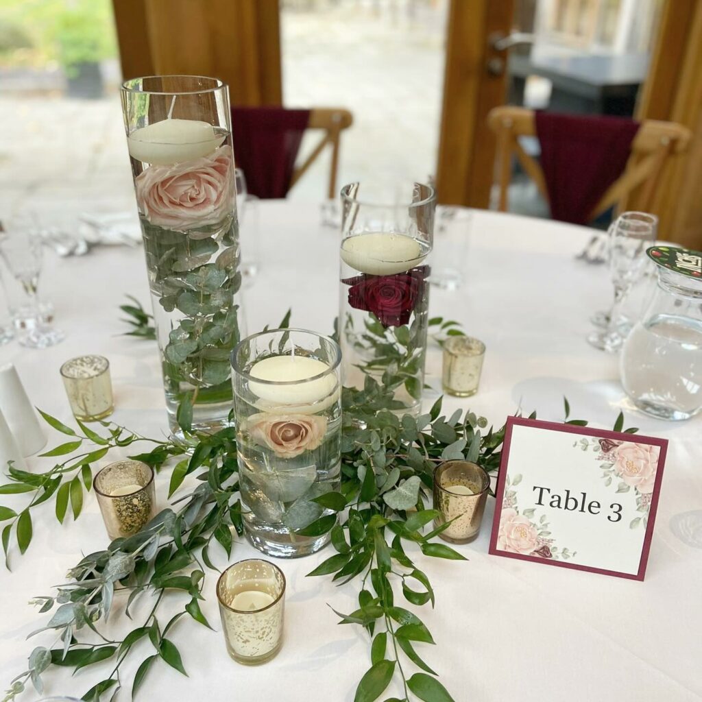 floating candle wedding centerpiece with flower and greenery