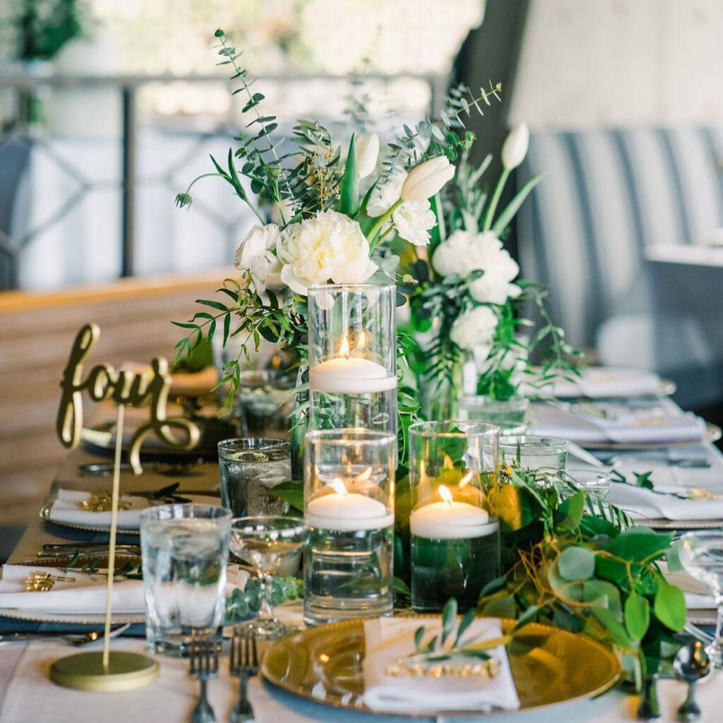 green and gold wedding centerpiece with floating candles