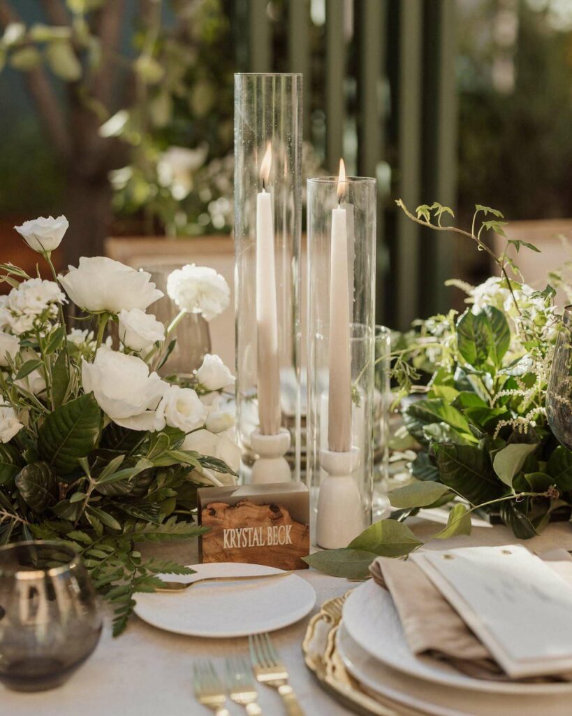 ivory and green taper candle wedding centerpiece with glass case for sleek and royal elegance