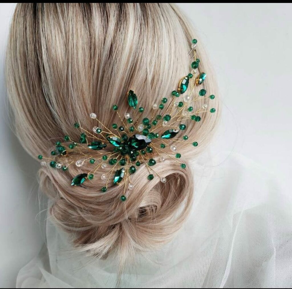 low bun wedding hairstyle with gorgeous green and gold wedding hairpiece