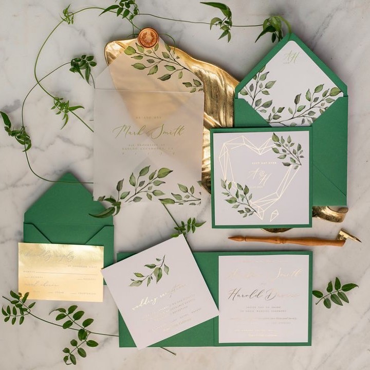 mixture of white, gold and green wedding invitation card with transparent envelope