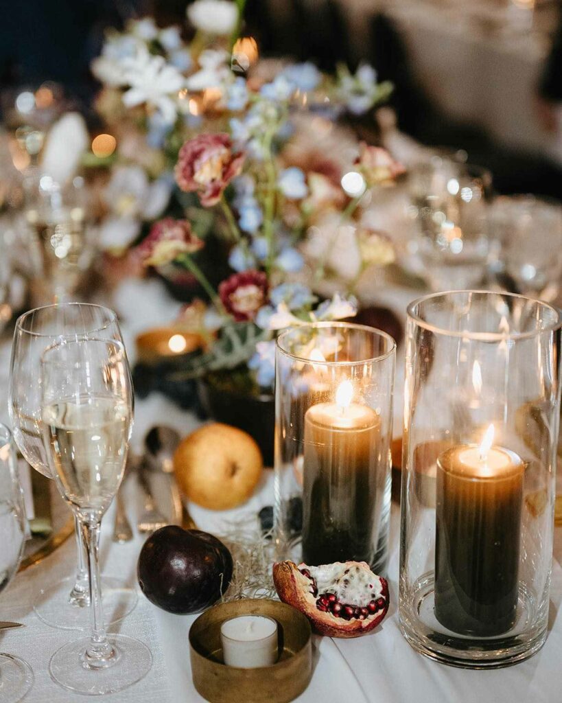 wedding centerpiece with moody pillar candles and fruits settings