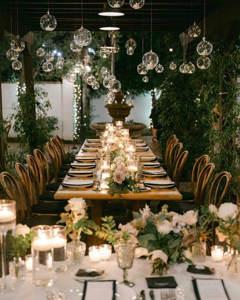 wedding reception table setting with candles and greenery